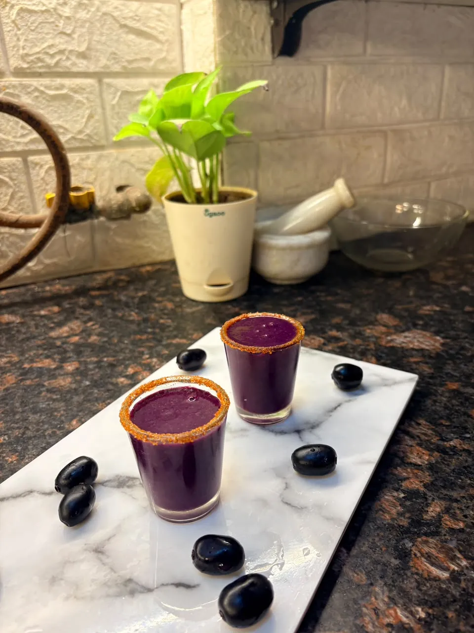 Two purple drinks served in small glasses